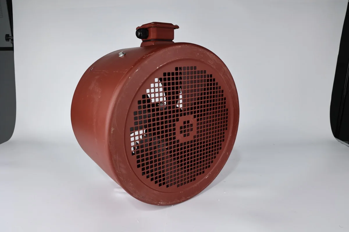 Red enclosed fan housing with a front inlet guard and top terminal enclosure on a studio background