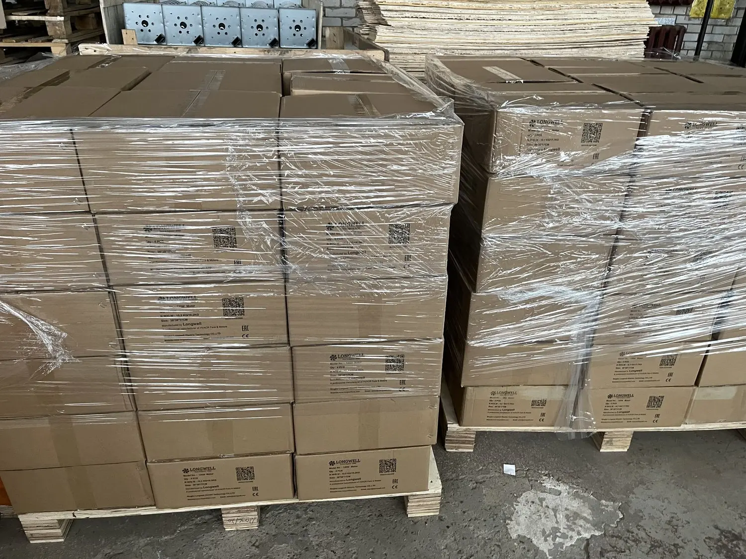 Stretch-wrapped pallets of LONGWELL motor cartons in a customer warehouse, cartons marked CE and EAC