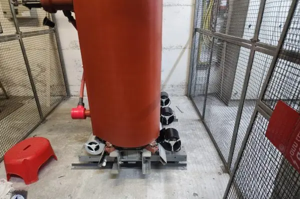 Four double-inlet centrifugal fans mounted on the base frame of a cast-resin dry-type transformer, inside a fenced