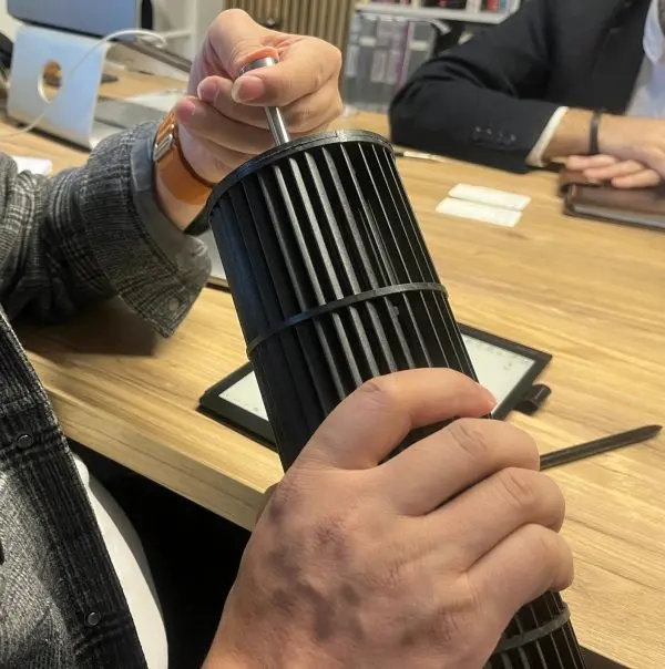 Hands-on inspection of a long tangential (cross-flow) fan impeller across the desk during a customer visit in Europ