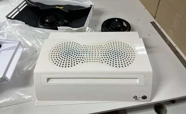A customer's compact filtration appliance opened on the assembly bench: two backward-curved centrifugal impellers w