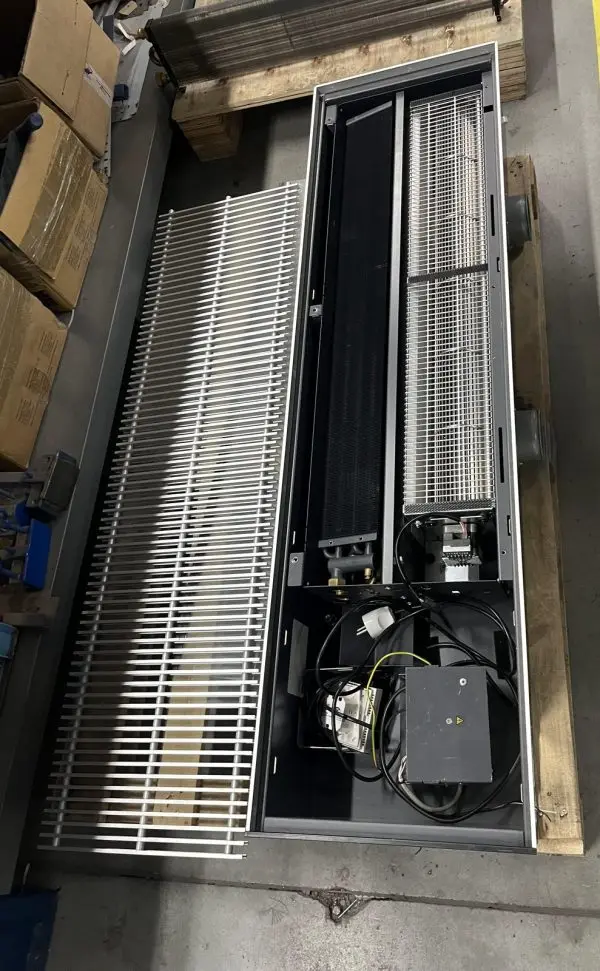 A floor-trench convector opened up for inspection on its pallet during a customer site visit: the linear bar grille