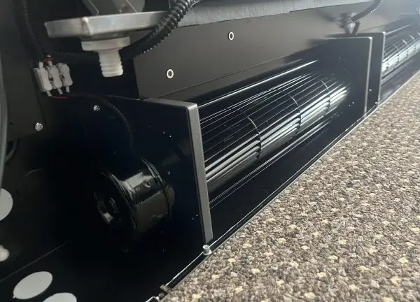 Inside a customer's long linear terminal unit with the cover removed: a cross-flow (tangential) impeller and its en