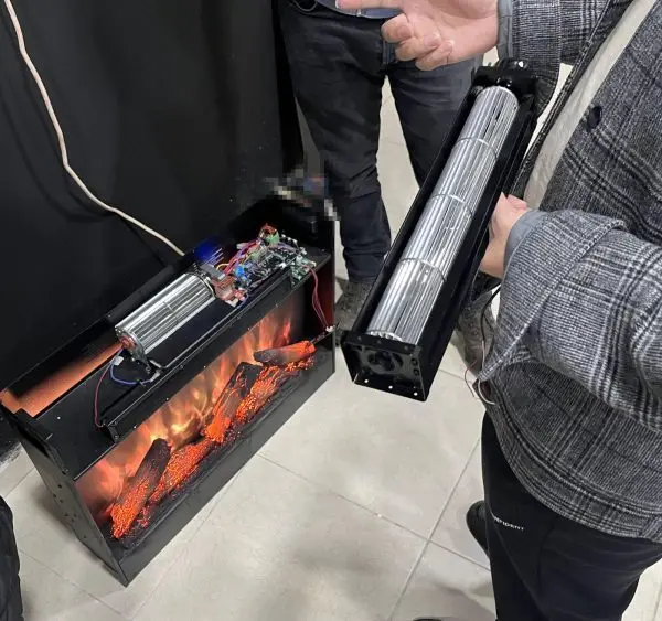 An electric-fireplace unit opened up on the customer's floor during a December 2023 visit: a cross-flow (tangential