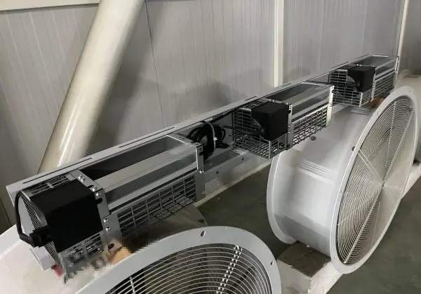 Three tangential (cross-flow) fan modules bolted onto a fabricated steel mounting rail with a sheet-metal outlet pl